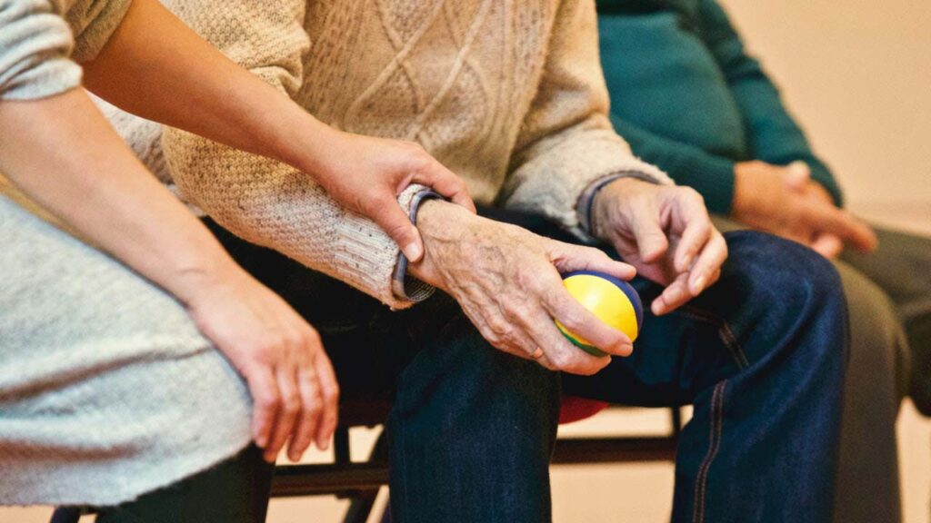 Woman hold hand of older man with ball in his hand