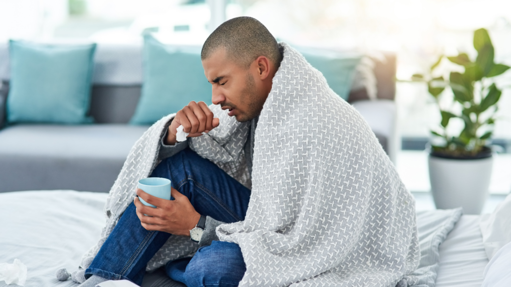 Man with cold wrapped in blanket